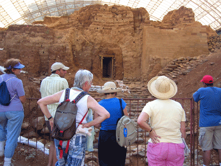 Group listening to Genesis 14 by Dan's Middle Bronze Age mud-brick gate