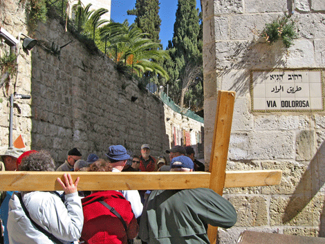 Pilgrims carrying the cross as they walk the Stations of the Cross