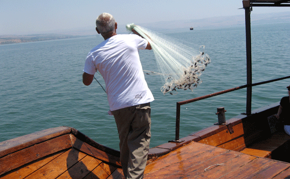 A fisherman casting his net out into the Sea of Galilee